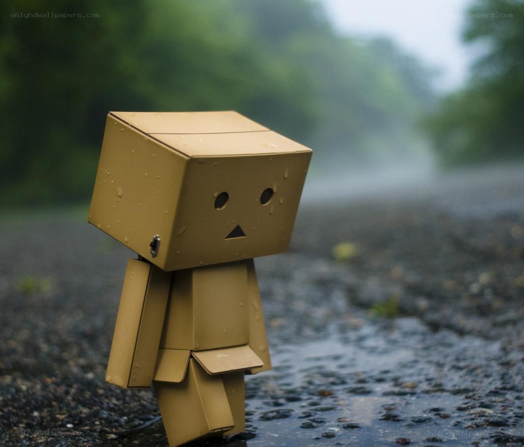 Sad cardboard robot in the rain