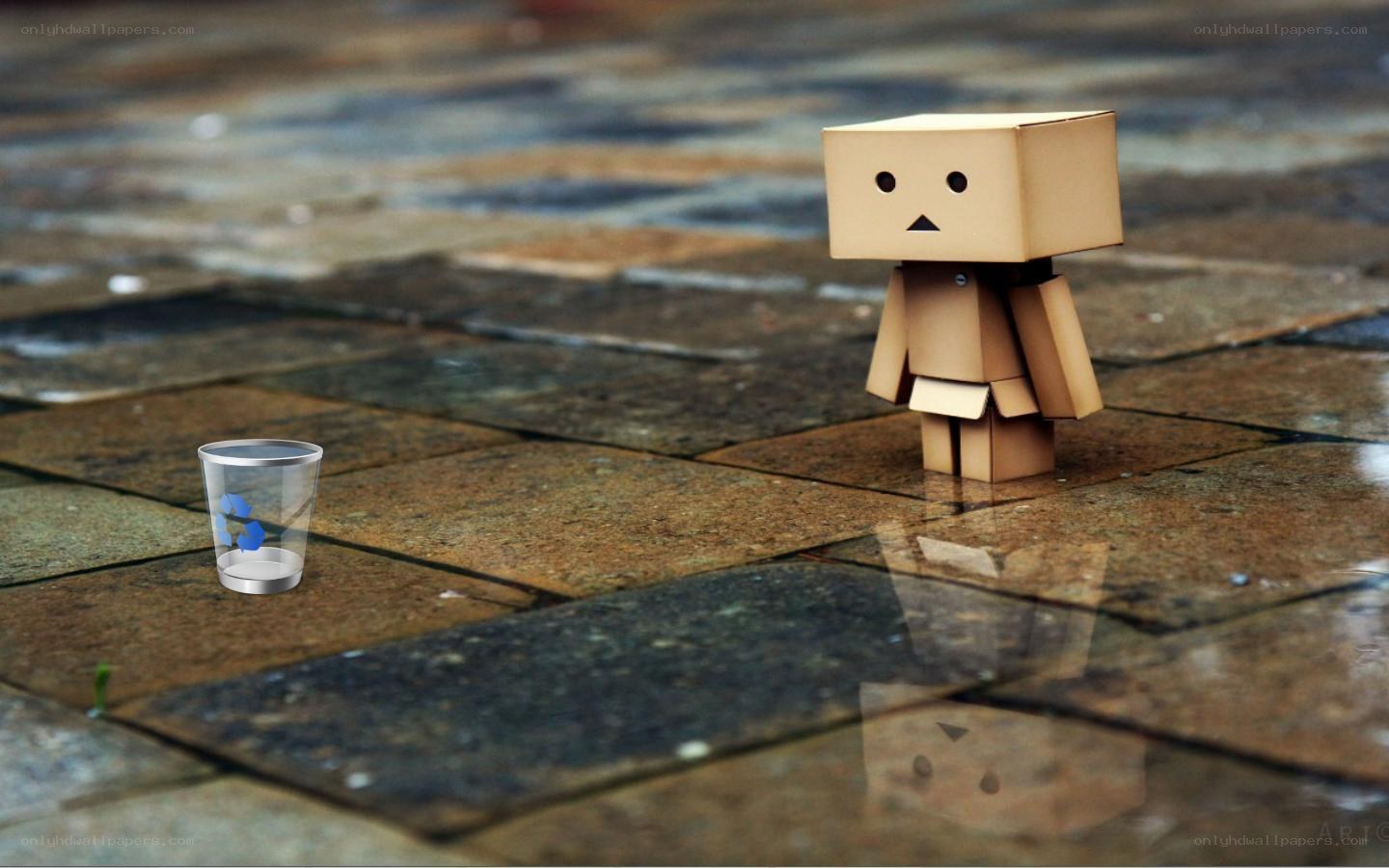 Sad cardboard robot on wet pavement