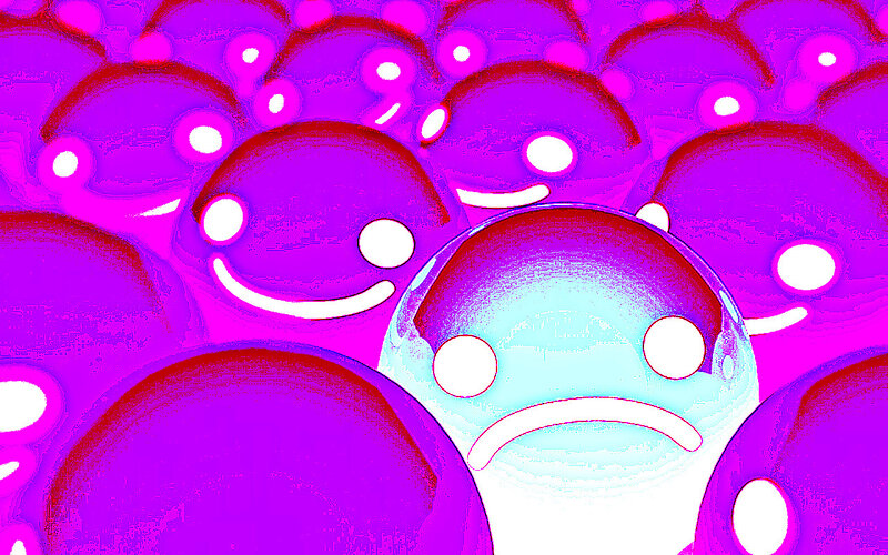 sad face among smiling faces