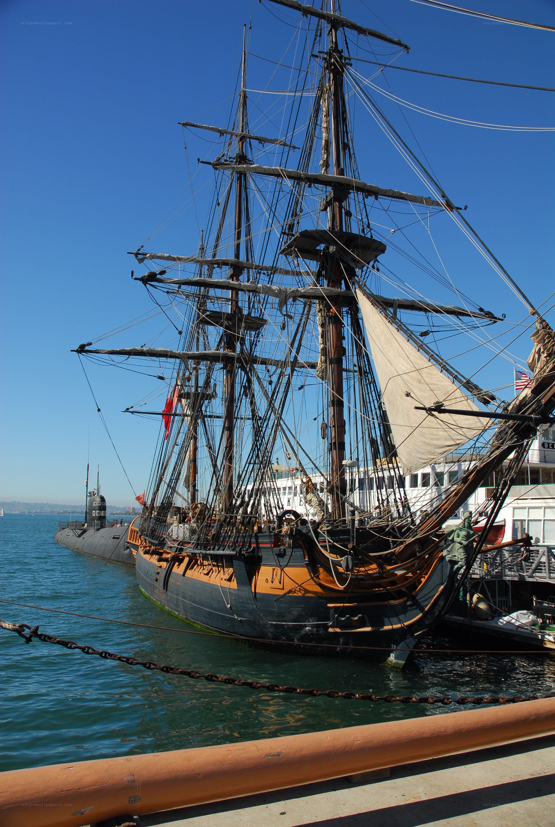 Sailboat and submarine at dock