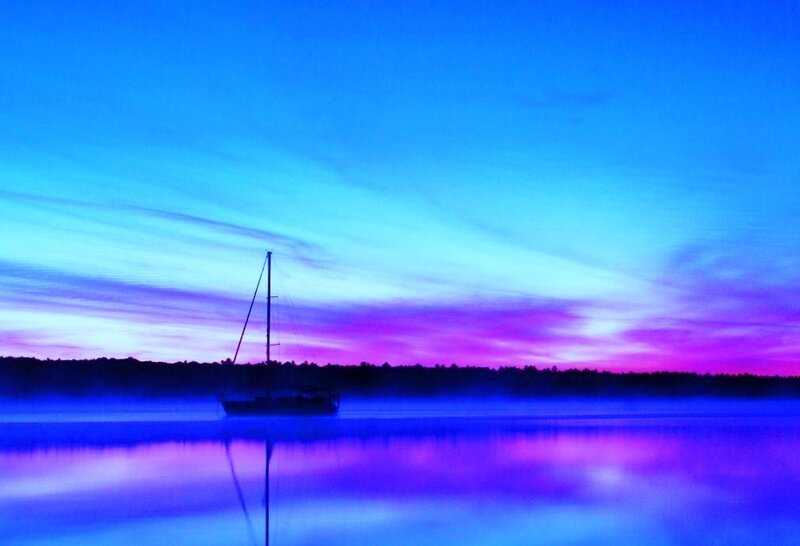 sailboat at dawn on a misty lake