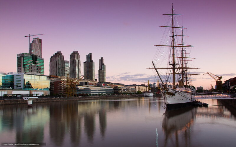 sailboat at dusk in city harbor