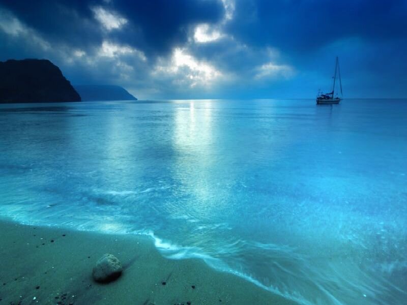 Sailboat at dusk on calm sea