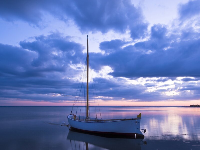 Sailboat at dusk on calm water