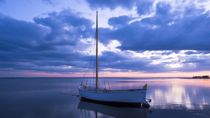 Sailboat at dusk on calm water
