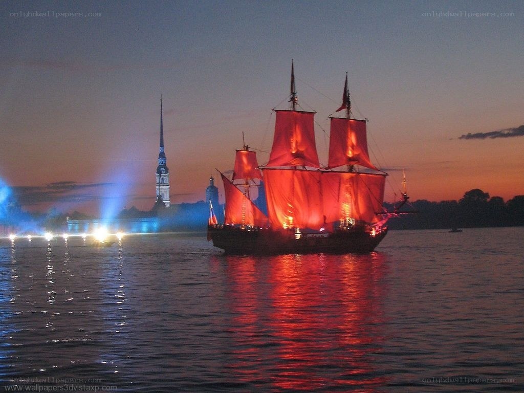 sailboat at dusk with city lights