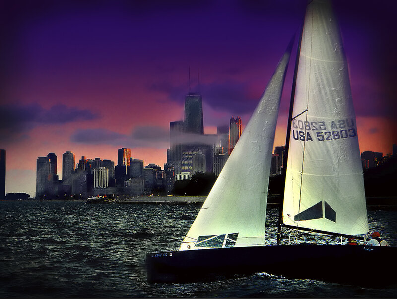 Sailboat at dusk with city skyline