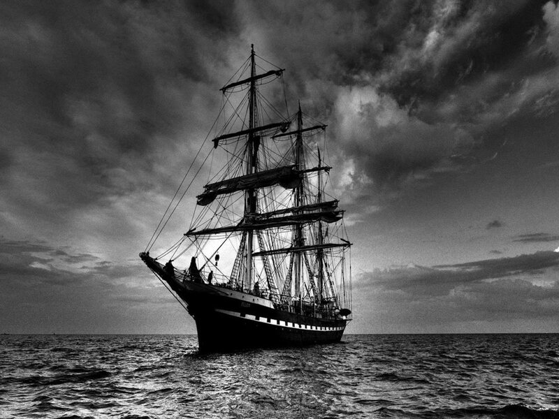 sailboat at sea under stormy sky