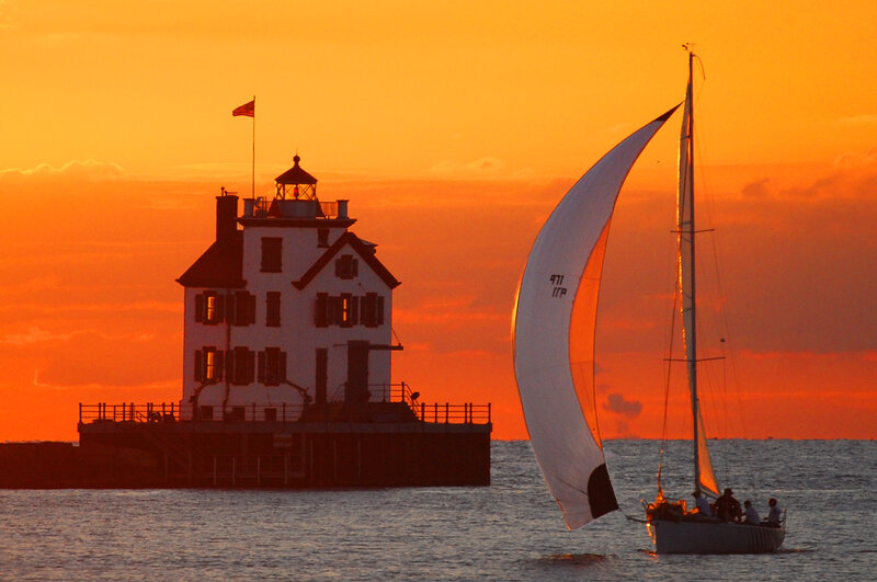Sailboat at sunset by lighthouse