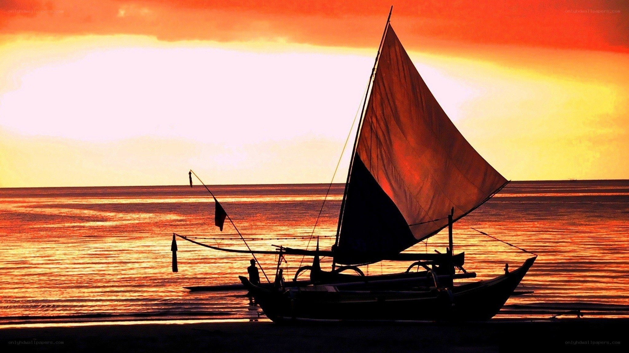 sailboat at sunset on beach
