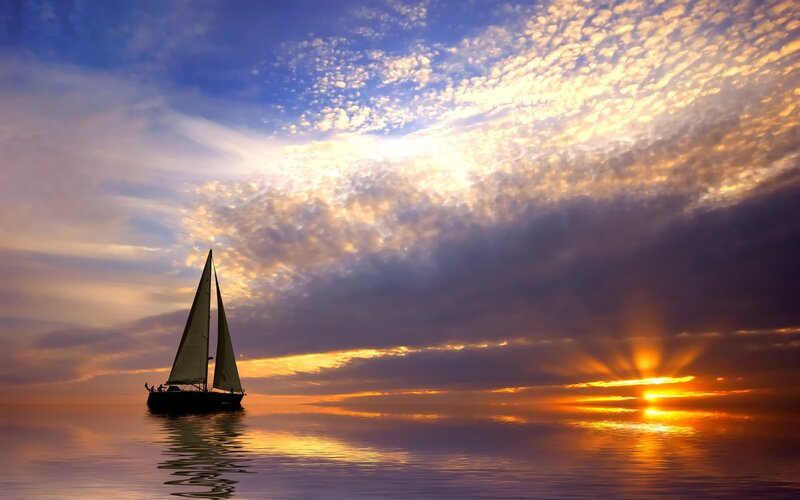 Sailboat at sunset on calm sea