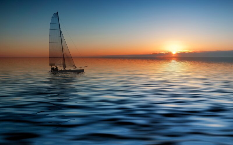 Sailboat at sunset on calm sea