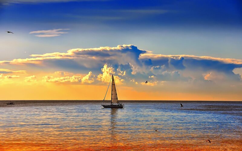 Sailboat at sunset on calm sea