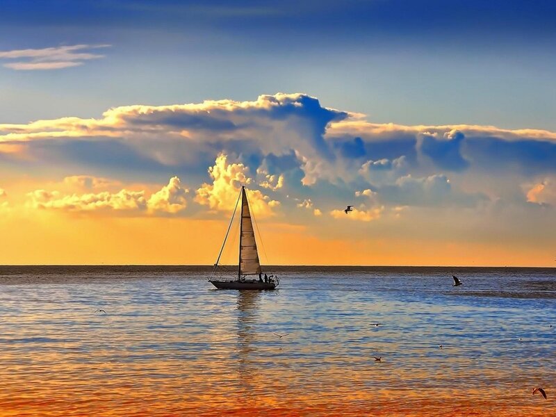 Sailboat at sunset on calm sea