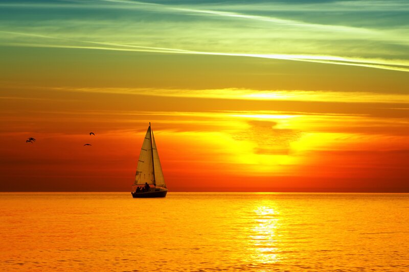 Sailboat at sunset on calm sea