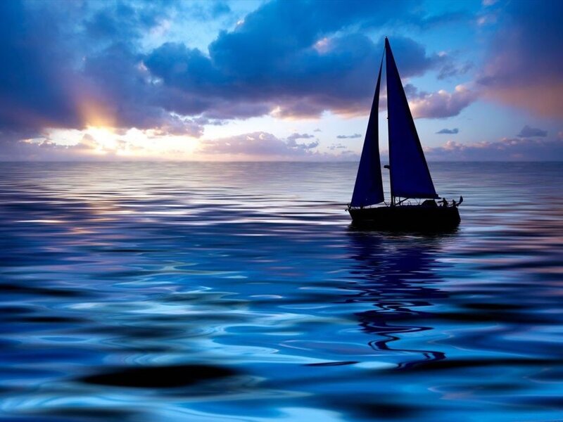 sailboat at sunset on calm sea