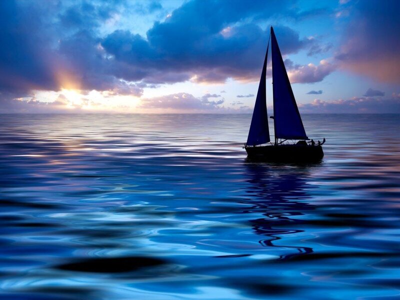 sailboat at sunset on calm sea