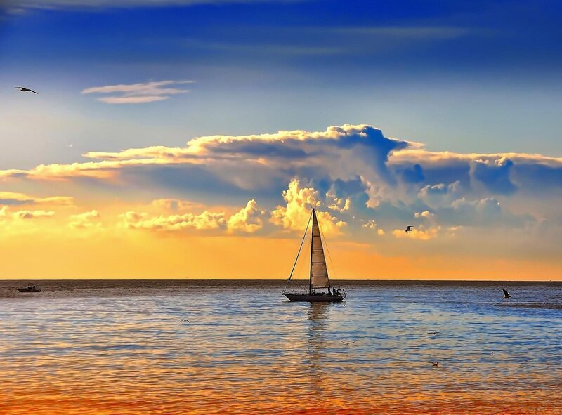 Sailboat at sunset on calm sea