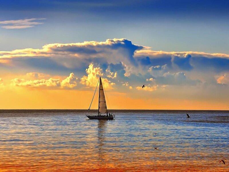 Sailboat at sunset on calm sea