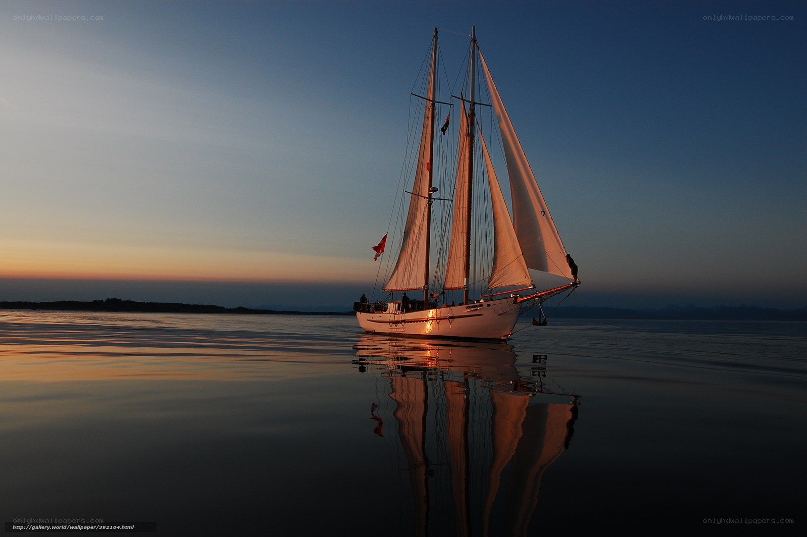 Sailboat at sunset on calm water