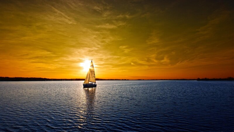 Sailboat at sunset on calm water