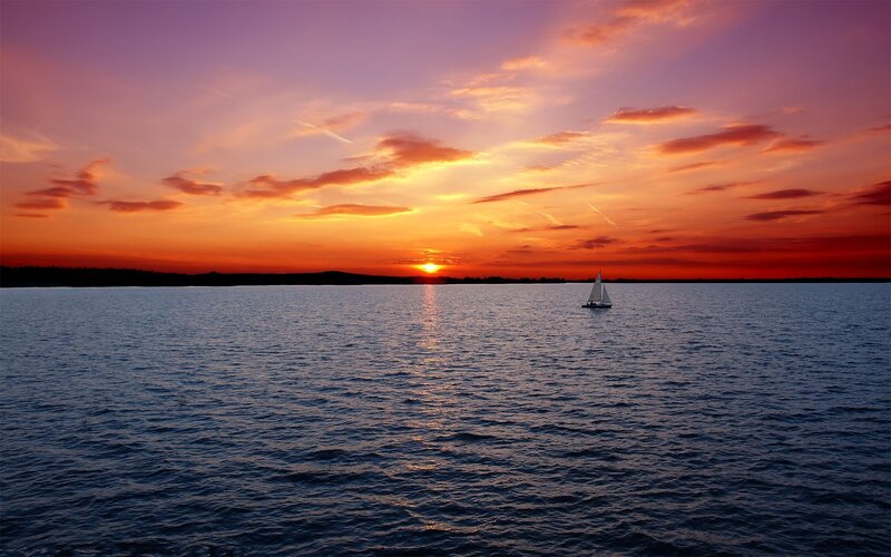 Sailboat at sunset on calm water