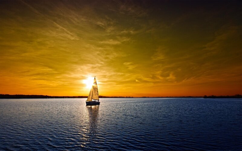 Sailboat at sunset on calm water