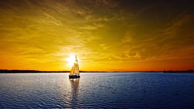 sailboat at sunset on calm water