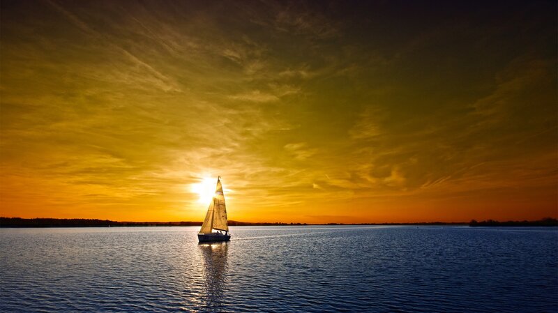 Sailboat at sunset on calm water