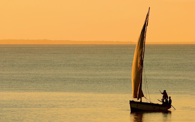 Sailboat at sunset on calm water