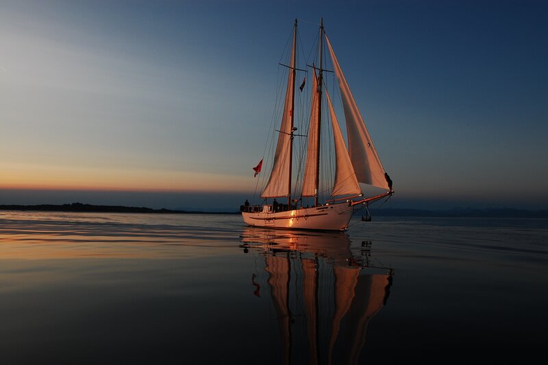 Sailboat at sunset on calm water