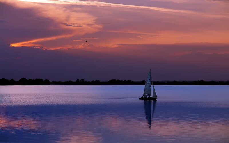 Sailboat at sunset on calm water
