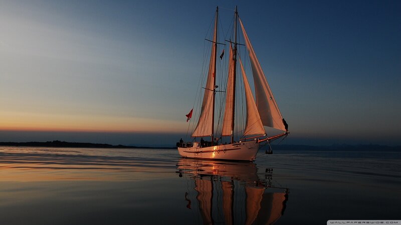 Sailboat at sunset on calm water