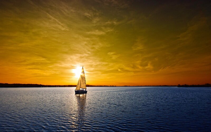 Sailboat at sunset on calm water