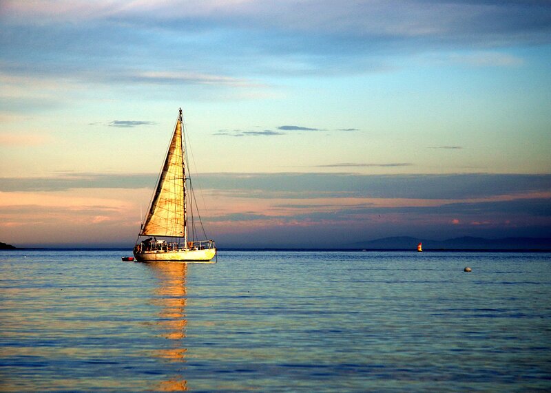 Sailboat at sunset on calm water