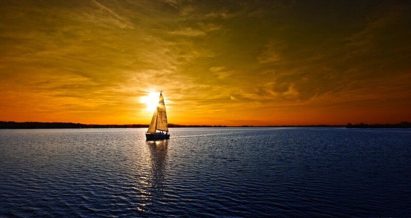 sailboat at sunset on calm water