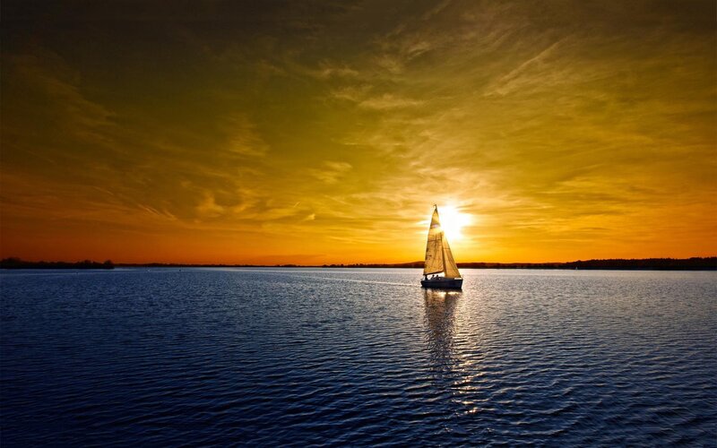 sailboat at sunset on calm water