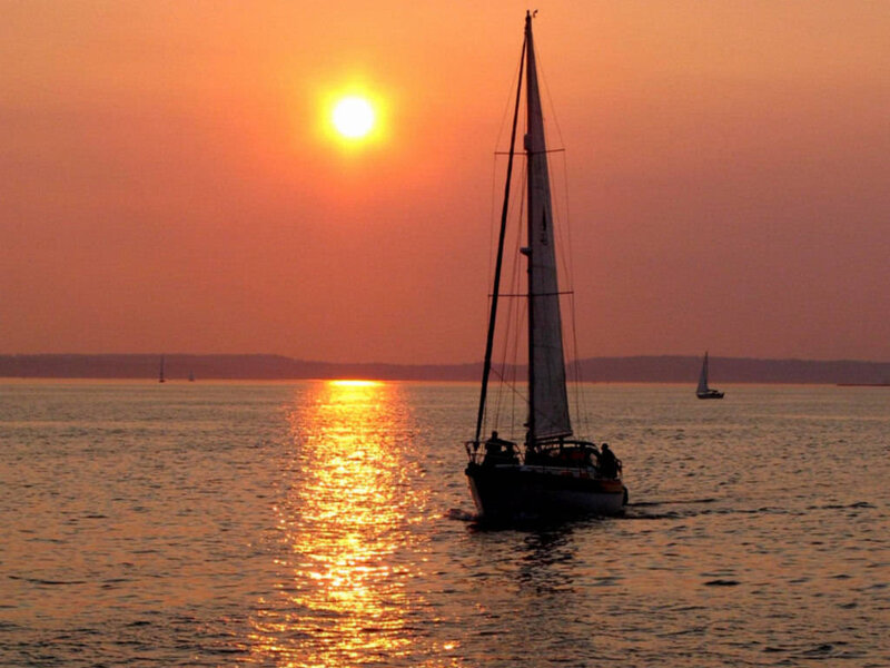 sailboat at sunset on calm water
