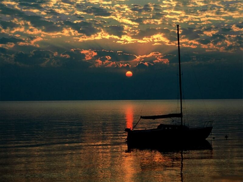 Sailboat at sunset on calm water