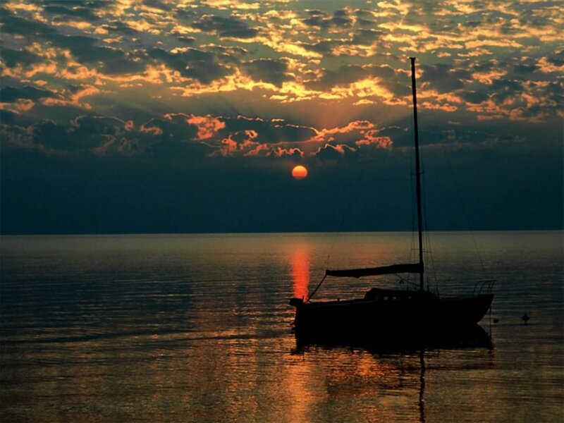 sailboat at sunset on calm water