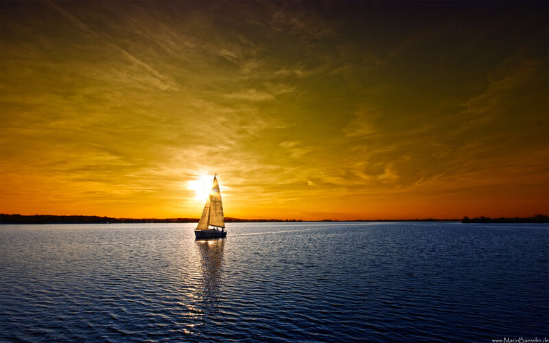 Sailboat at sunset on calm water