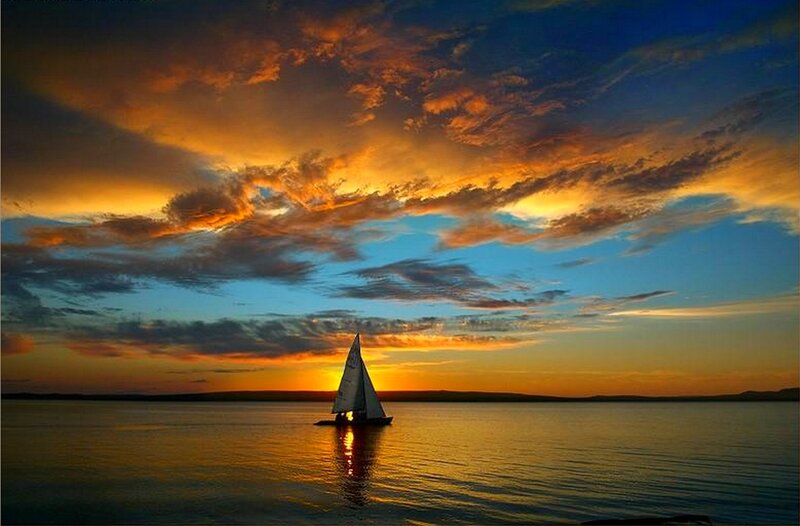 Sailboat at sunset on calm water