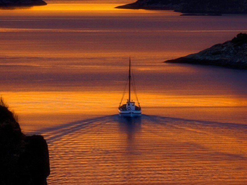 sailboat at sunset on calm water