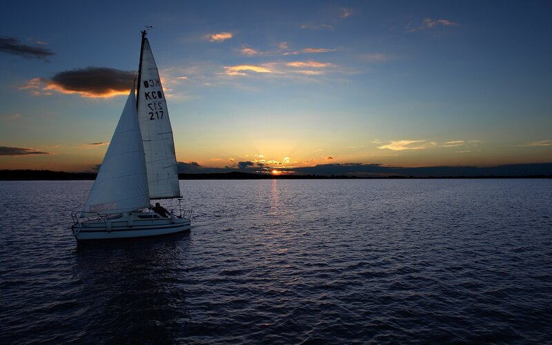 Sailboat at sunset on calm water