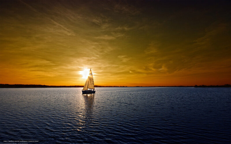 Sailboat at sunset on calm water
