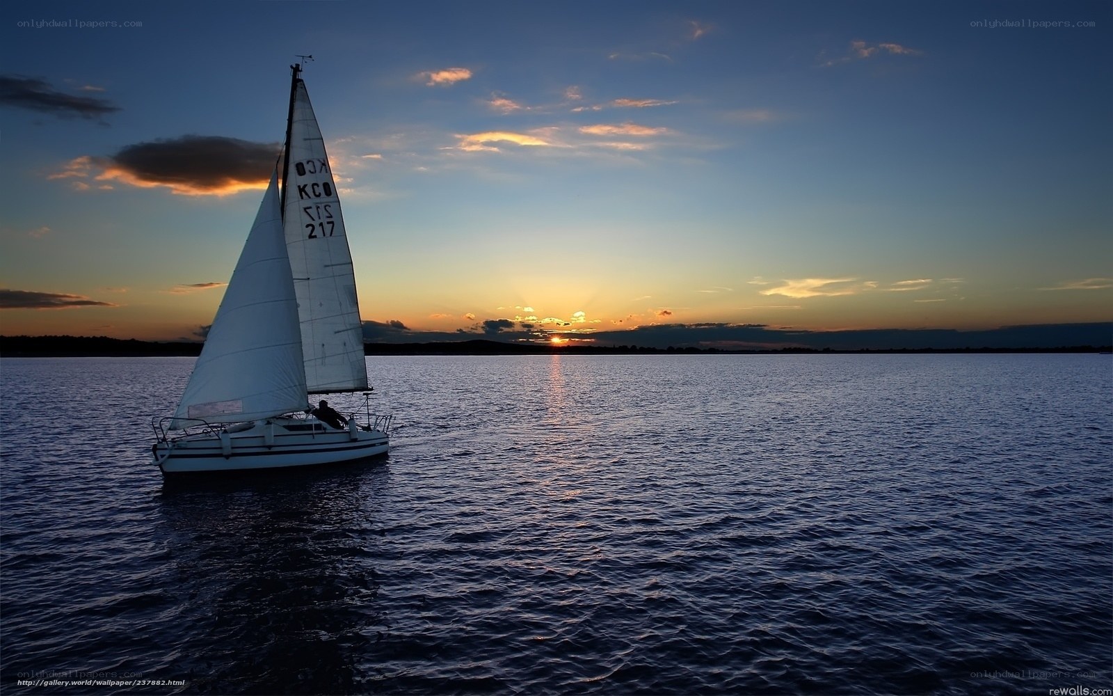 Sailboat at sunset on calm water