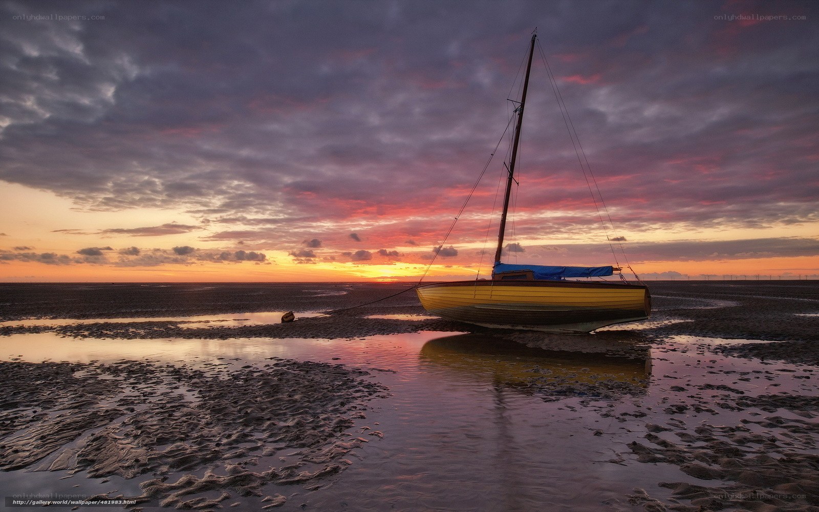 Sailboat at sunset on mudflats