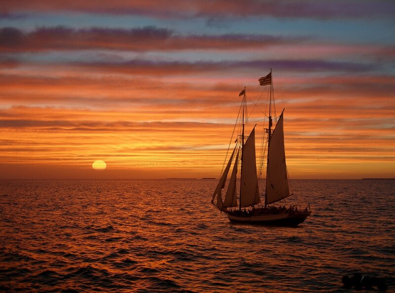 Sailboat at Sunset — Orange, Serene, Photograph, Sun, Ocean, Sky, Flag
