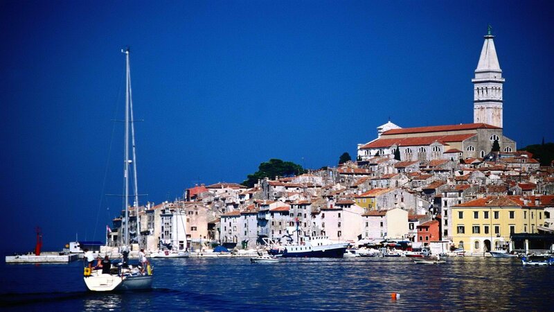 Sailboat in a coastal town harbor