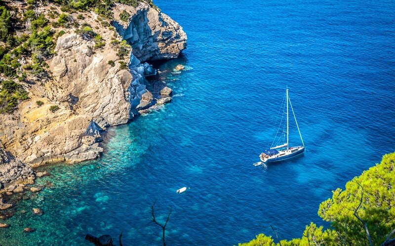 Sailboat in Blue Water — Serene, Afternoon, Photograph, Cliff